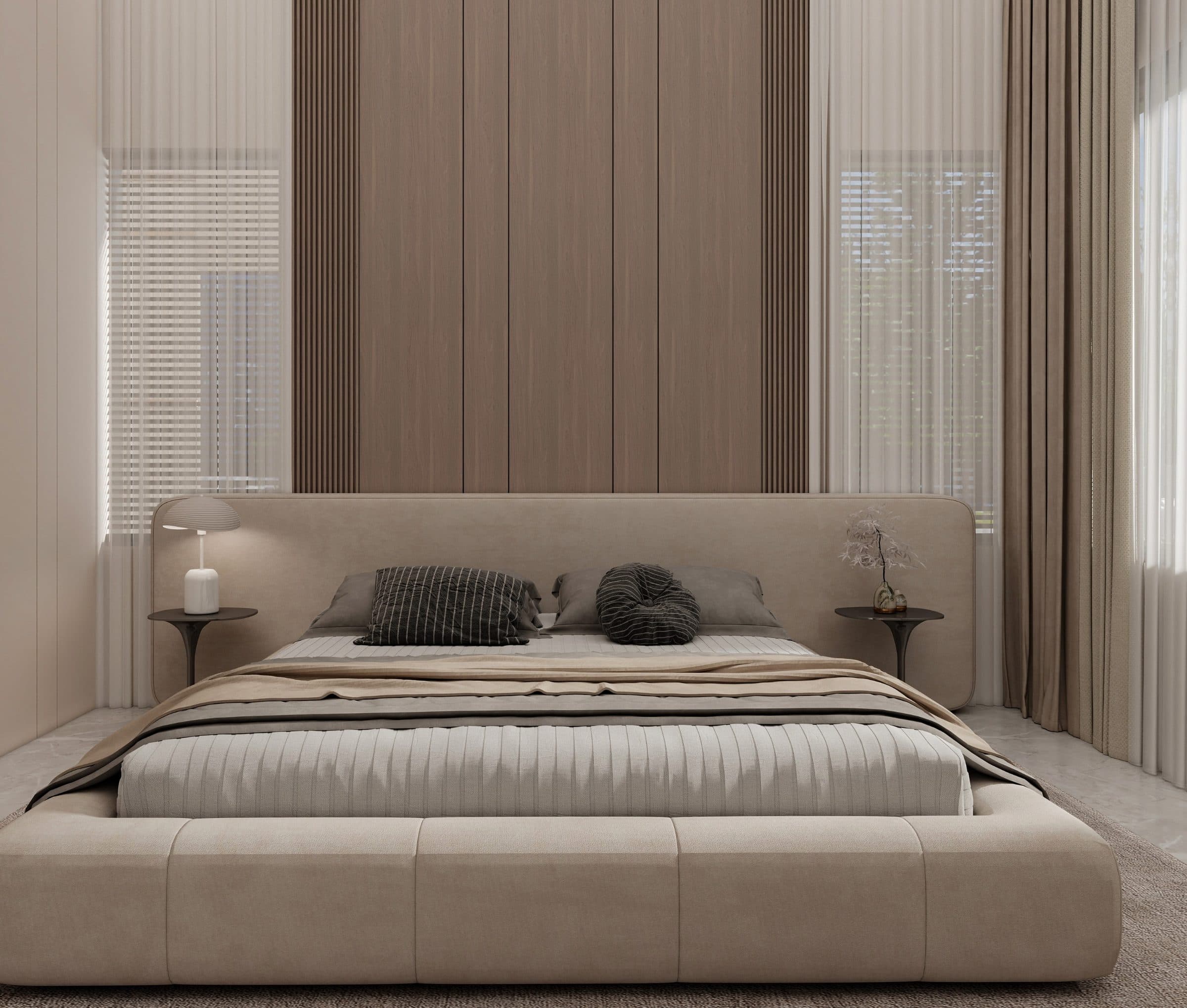 The bedroom head-on, the upholstered headboard running past the bed to carry slim side tables