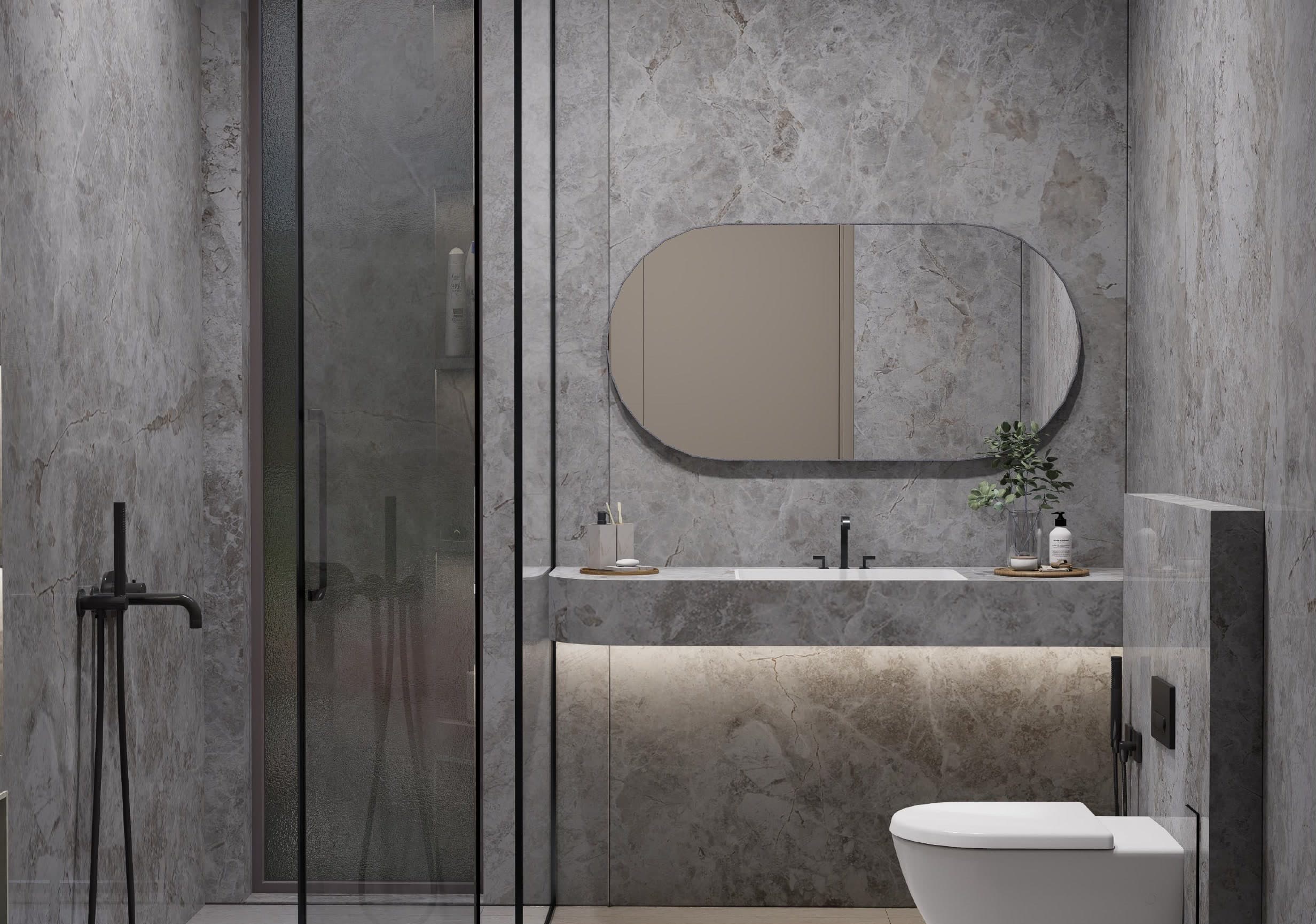Bathroom lined in grey marble, a pill-shaped mirror above the stone vanity and a walk-in shower alongside