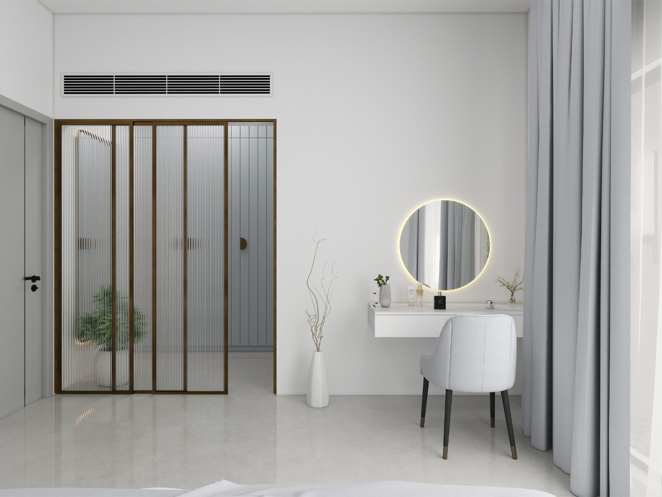 Bedroom dressing table with a backlit round mirror, beside a brass-framed reeded glass door